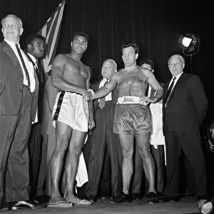 Muhammad Ali (left) and Brian London shake hands at the weigh-in ahead of their
