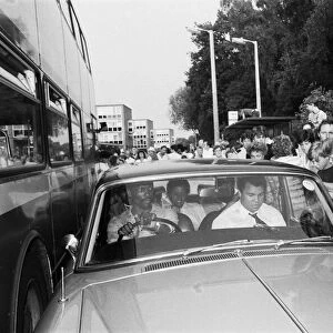Muhammad Ali in the passenger seat makes his way through Coventry mobbed by fans