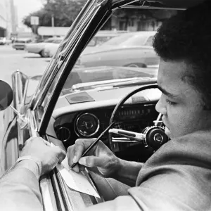 Muhammad Ali signing an autograph for a fan. 31st August 1967 Muhammad Ali signing an autograph for a fan. 31st August 1967