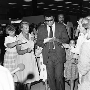 Muhammad Ali signing autographs for fans in England before his journey back to Chicago