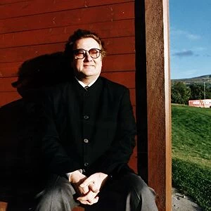 Music - Singer and songwriter Gerry Rafferty entertainer sitting brown fence green field