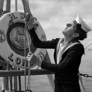 A naval rating raising the white ensign aboard the County Class cruiser HMS London which A naval rating raising the white ensign aboard the County Class cruiser HMS London which