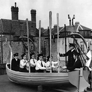 Naval training corp girls learning how to row a boat during the war