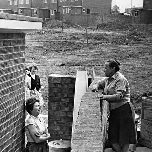 Neighbours Mrs Moria Foster (left) and Mrs Phillis Tanner chat over the garden wall