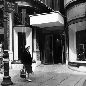 The new and old. Outside the entrance to the department store still stands the sign The new and old. Outside the entrance to the department store still stands the sign