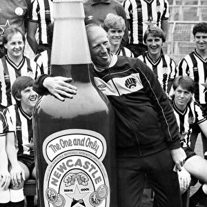 Newcastle United manager Jack Charlton clowns around with a giant bottle of Newcatle