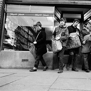Newspaper round boys leaving the newsagents with their newspapers, ready for delivery