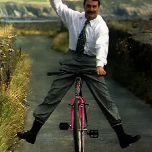 Nigel Mansell Formula One Racing Driver Riding A Bicycle Down A Country Lane Nigel Mansell Formula One Racing Driver Riding A Bicycle Down A Country Lane