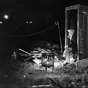 Night Watchman keeps himself warm by a brazier whilst guarding road works in Eastleigh