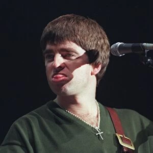 Noel Gallagher Oasis pop group December 1997 Sticking tongue out playing guitar