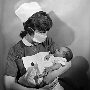 A nurse holding a baby at Carter Bequest hospital. Circa 1973