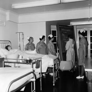 Nurses receiving instruction from Miss V Thomas (in surgical gown) on patient care Nurses receiving instruction from Miss V Thomas (in surgical gown) on patient care