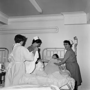 Nurses receiving instruction from Miss V Thomas (in surgical gown) on patient care Nurses receiving instruction from Miss V Thomas (in surgical gown) on patient care