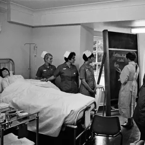 Nurses receiving instruction from Miss V Thomas (in surgical gown) on patient care Nurses receiving instruction from Miss V Thomas (in surgical gown) on patient care