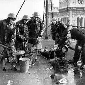 Office girls on a city roof being instructed how to fight an incendiary bomb Office girls on a city roof being instructed how to fight an incendiary bomb