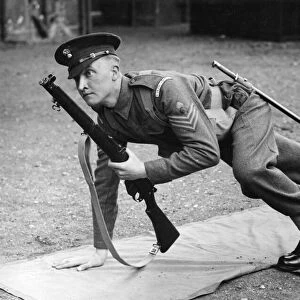 An officer from the Grenadier Guards getting into a laying combat position