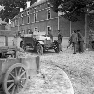 Officers showing their passes to Belgian peasants manning a road block on the road