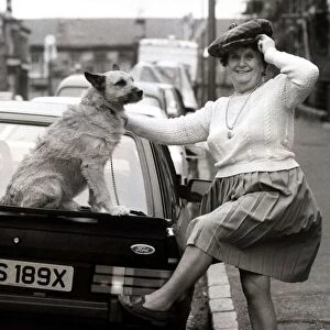 Old lady with her dog on a car circa 1990