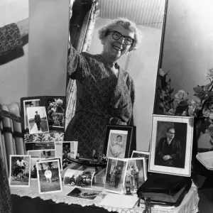 Old woman smiling at bedroom mirror in her newly-built Home. 9th october 1963 Old woman smiling at bedroom mirror in her newly-built Home. 9th october 1963