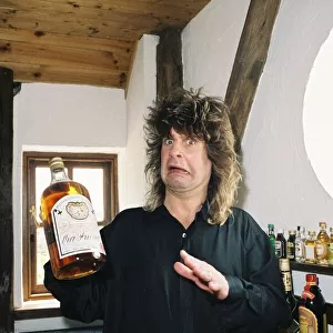 Ozzy Osbourne rock singer with the group Black Sabbath, holding a bottle of whiskey at