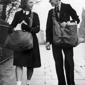 A paperboy and papergirl, dressed in their school uniforms A paperboy and papergirl, dressed in their school uniforms