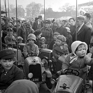 Parents watch as their children ride on a merry-go-round at Blackheath Fair April