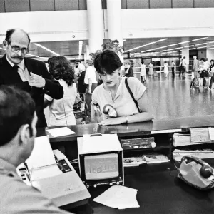 Passengers booking in their luggage at Gatwick Airport. 21st June 1983 Passengers booking in their luggage at Gatwick Airport. 21st June 1983