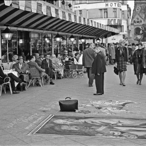 Passers by stop and admire the work of street artists, who uses the pavements of