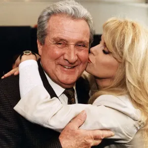 Patrick Macnee being kissed by Joanna Lumley photo print, February 1995