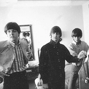 Pau McCartney, Ringo Starr and George Harrison with a one-armed bandit machine