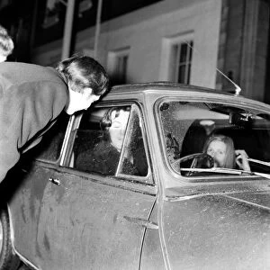 Paul McCartney of the Beatles in his mini car with girlfriend Linda Eastman outside