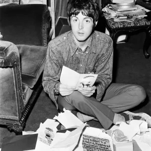 Paul McCartney of The Beatles sitting on the floor cross legged as he opens up birthday Paul McCartney of The Beatles sitting on the floor cross legged as he opens up birthday