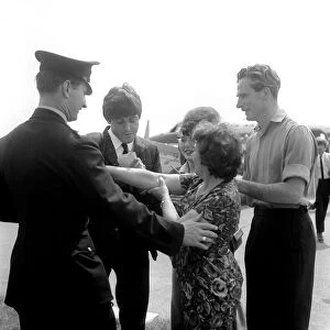 Paul McCartney a signing autographs for fans after arriving at Luton Airport, May 1964