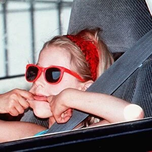 Paula Yates daughter-Peaches in red sunglasses pulling face in back of car on way to