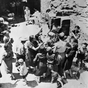 Gli abitanti di Catania, in Sicilia, si fanno avanti per ricevere cibo distribuito dagli uomini della Royal Air Force. Gli abitanti di Catania, in Sicilia, si fanno avanti per ricevere cibo distribuito dagli uomini della Royal Air Force.