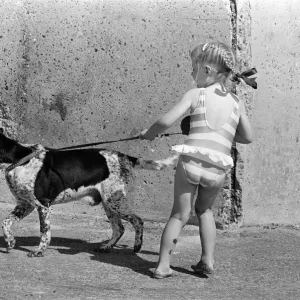 People enjoying a day at Crosby beach. A young girl with a dog. Crosby, Merseyside