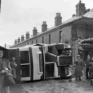 People gather round an overturned bus Bus in Sparbrook, Birmingham following an air raid