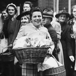 Print of a woman holding a basket of food stuffs, May 1945 Print of a woman holding a basket of food stuffs, May 1945