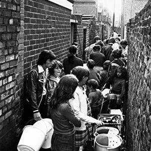 People queue in a back alley off David Street the Holy Land, in Dingle