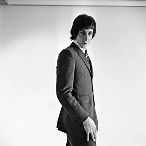 Pete Townshend of British rock group The Who, poses in the studio wearing suit and tie