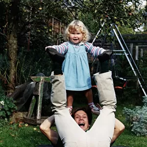 Peter Duncan TV presenter of Blue Peter playing in the garden with his daughter