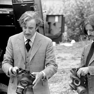 Peter Sellers and Ringo Starr prepare to put on gas masks in a scene from the film