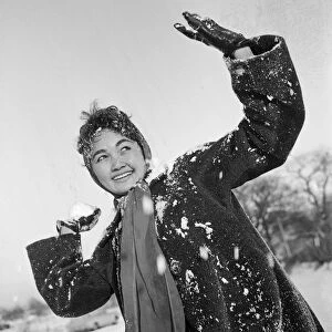 Philippine dancers have a snowball fight in London. One of the woman throwing