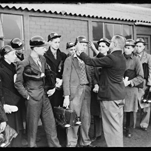 A photograph of a group of Bevin Boy miners receiving their equipment on their