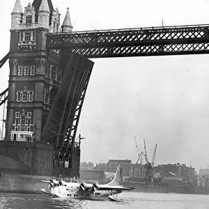 Picture shows the first flying boat on the Thames for 21 years-passing under Tower Bridge