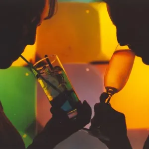 A picture of a woman drinking a cocktail enjoying a night out