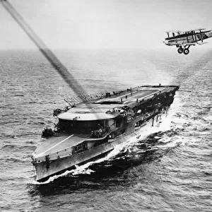 A plane from HMS Furious passing over the aircraft carrier while manoeuvering to alight