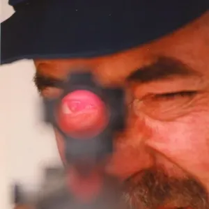 A police marksman aims his gun