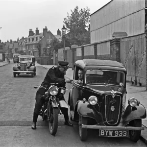 A police motorcyclists issues a warning to a motorist in Hampton, Middlesex A police motorcyclists issues a warning to a motorist in Hampton, Middlesex