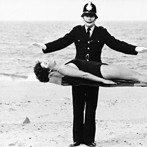 Policeman Bob Averill from Wallsend Tyne and Wear levitates Julia Wall on the sands of
